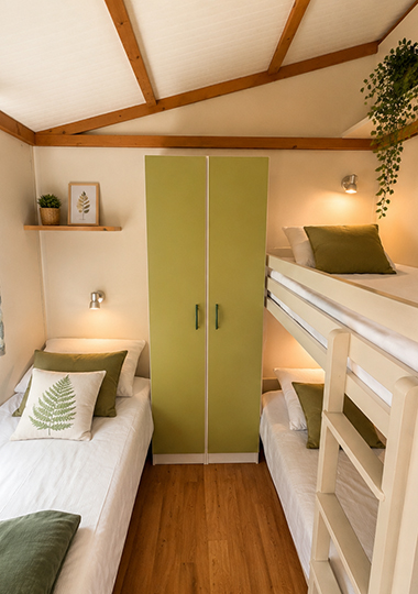 Zimmer mit 2 Einzelbetten im Ferienhaus „Morea“, das auf dem Campingplatz Saint-Point Lamartine in Burgund vermietet wird