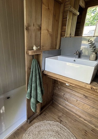 Salle d’eau avec douche, lavabo et WC privatifs de la tente Écolodge premium : hébergement insolite en Bourgogne au camping de Saint-Point Lamartine en Bourgogne