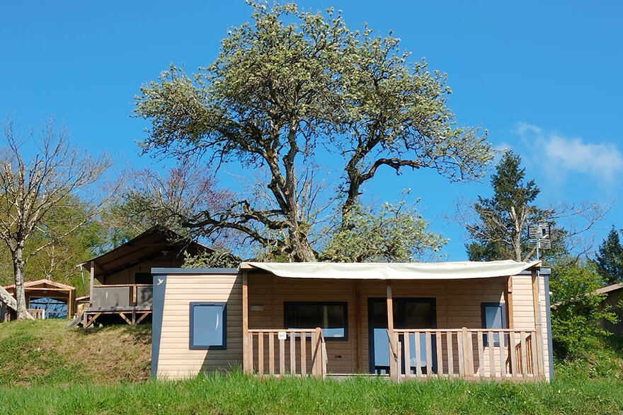 Vue du mobil-home Premium 35 m² avec terrasse couverte et vue sur le lac en location en Bourgogne au camping de Saint-Point Lamartine en Saône-et-Loire