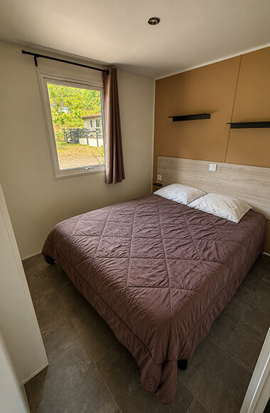 Chambre avec lit 2 places du mobil-home Premium 35 m² avec vue sur le lac en location en Bourgogne au camping de Saint-Point Lamartine en Saône-et-Loire